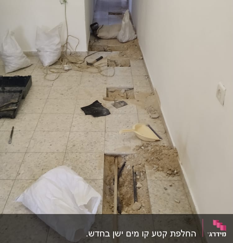 רצפה פתוחה עם צינורות וכלי עבודה של אינסטלטור